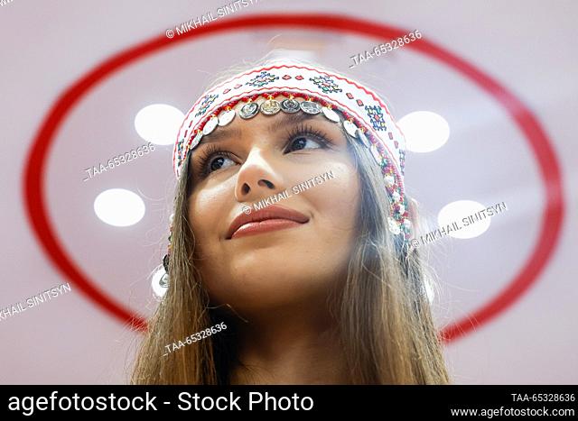 RUSSIA, MOSCOW - NOVEMBER 29, 2023: A model showcases traditional dress at a stand of the Mari El Republic at the Russia Expo international exhibition and forum...