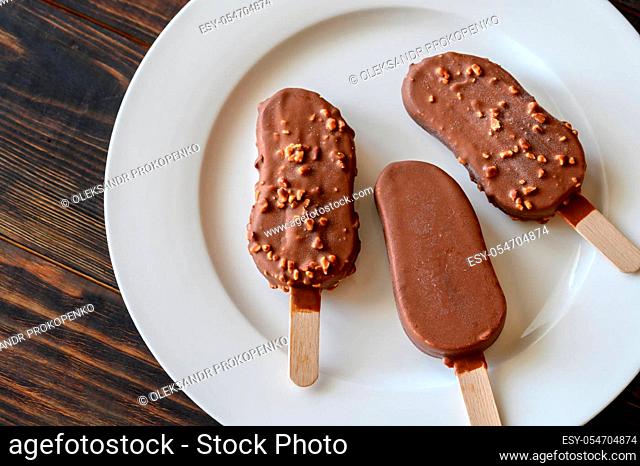 Chocolate-covered vanilla ice cream bars on the white plate