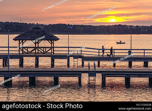 Sunset over wooden pier on Narie Lake located in Ilawa Lakeland region, view from Kretowiny village, Warmia and Mazury province of Poland