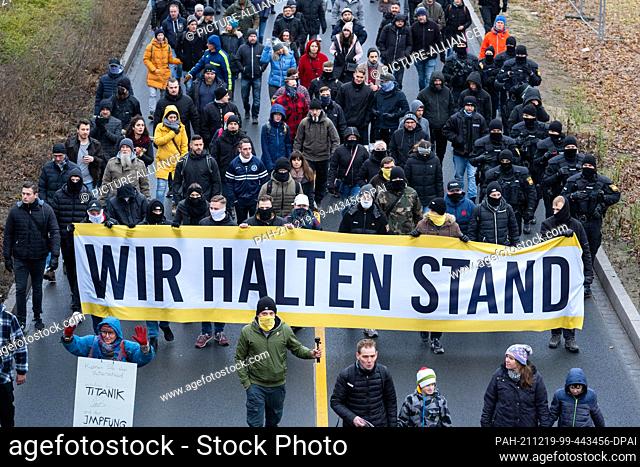 19 December 2021, Bavaria, Nuremberg: Demonstrators march towards Nuremberg's Südstadt with banners such as ""We stand firm""