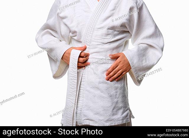 Stages of correct tying of the belt by a teenager on a sports kimono, step two