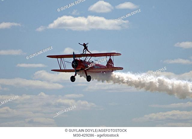Carol Pilon performing wingwalking on Stearman biplane during airshow. Bagotville military base, Quebec, Canada