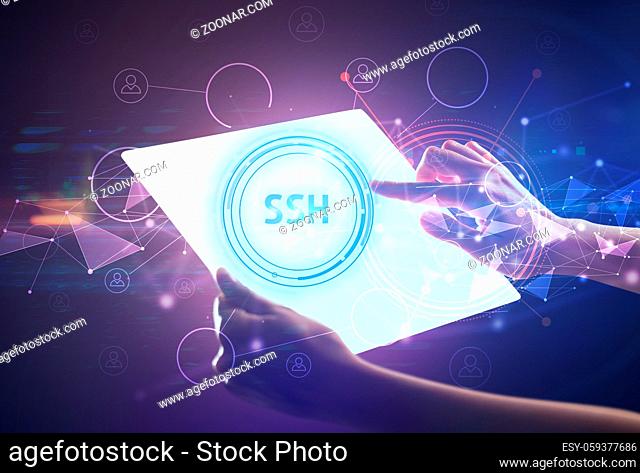 Hand holdig futuristic tablet with SSH inscription, modern technology concept