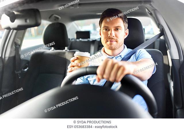 man or driver with takeaway coffee cup driving car