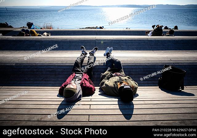 28 February 2021, Baden-Wuerttemberg, Ìberlingen: A young couple enjoys the beautiful weather at Lake Constance. Photo: Christoph Schmidt/dpa