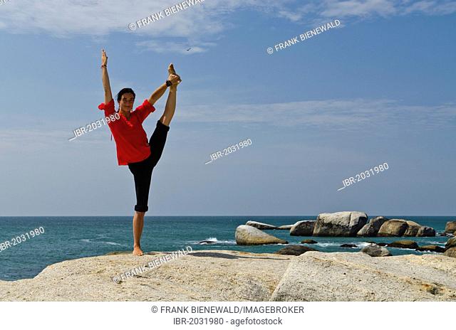 Woman in a yoga position, Anjaneyasana, by the sea in Kanyakumari, Tamil Nadu, India, Asia
