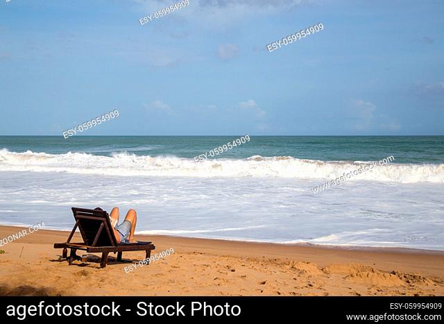 Tangalle, Sri Lanka - July 31, 2018: Young man relaxing on a beach chair