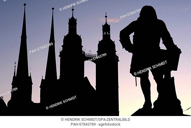 The silhouettes of the market church of 'Unser Lieben Frauen' and the statue of composer 'Georg Friedrich Haendel' (R) stand out against a backdrop of a late...