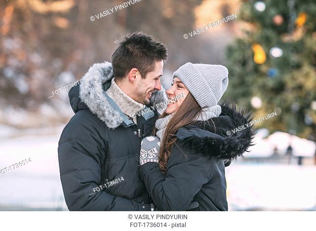 Smiling couple wearing warm clothing standing outdoors