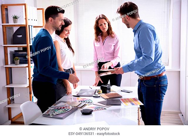 Group Of Young Businesspeople Working Together Choosing Color Palette