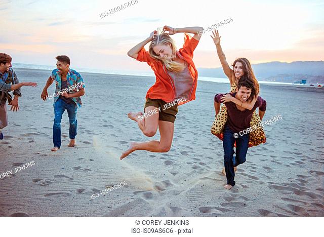 Group of friends fooling around on beach