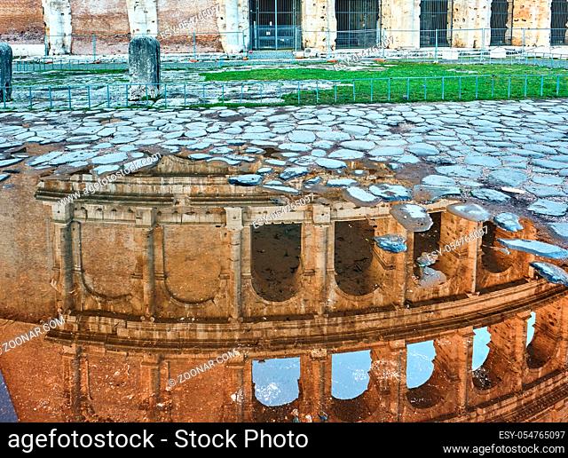 Cobblestone brick paved wet street with Colosseum reflection in Rome, Italy