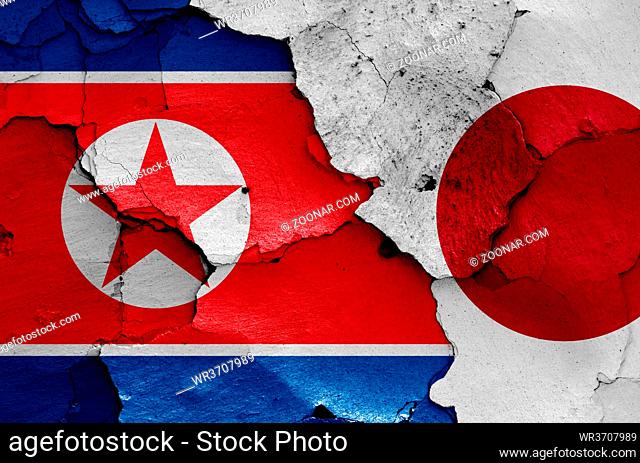 flags of North Korea and Japan painted on cracked wall