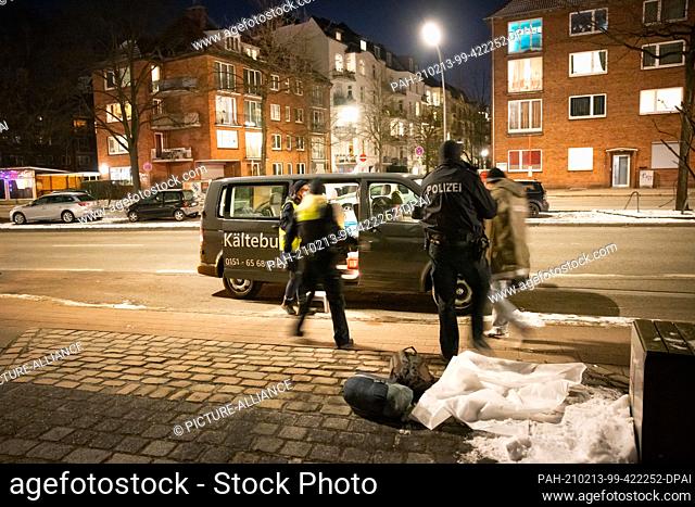 12 February 2021, Hamburg: Two police officers accompany a homeless person to the cold bus. The cold bus in Hamburg has been in existence since January 2019