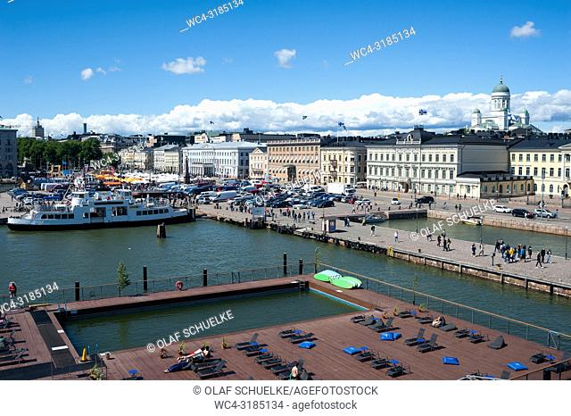 Helsinki, Finland, Europe - An elevated view of the Allas Sea Pool terrace with the harbour, the central market square and the Presidential Palace in the...