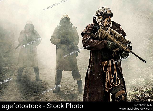 Nuclear post-apocalypse. Survivors in tatters and gas mask on the ruins of the destroyed city