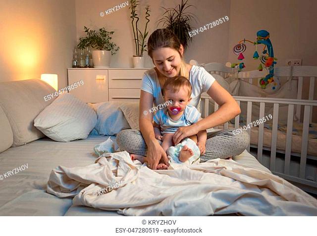 Toned image of mother changing diapers to her baby