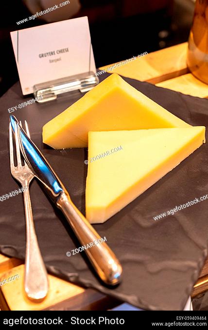 gruyere cheese on black stone plate in buffet line