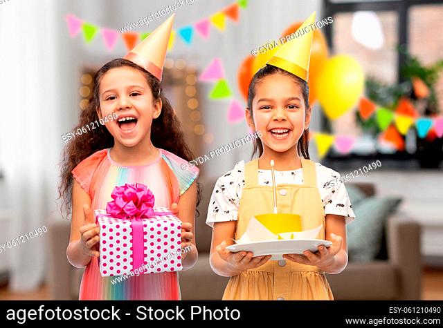 smiling girls with cake and gift on birthday party