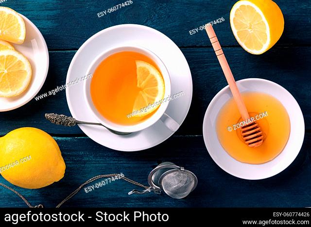 Lemon tea with honey, overhead flat lay shot on a rustic wooden background. Tasty citrus hot drink for cold winter days