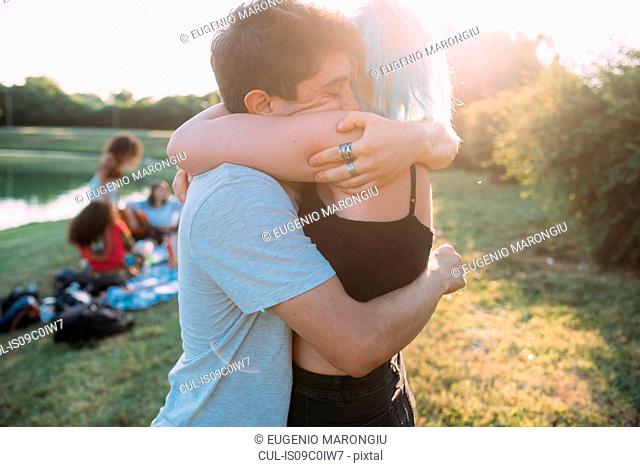 Couple hugging by lake