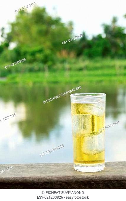 A Glass of beer with ice beside thailand river