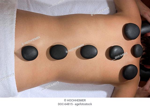 woman laying at the spa having hot stones on her back