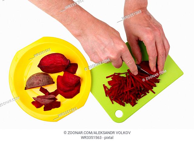 To cook a tasty vegetable soup beet must be finely chopped into stripes with hands and a sharp knife. Isolated on white top view studio shot