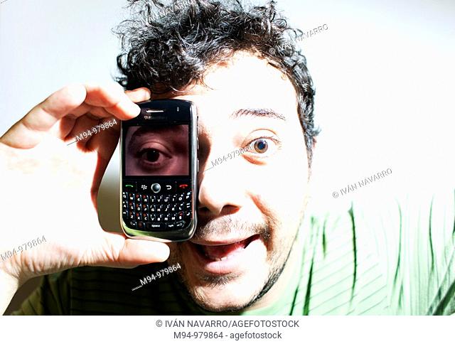 Man with a mobile phone with a photography of his eye