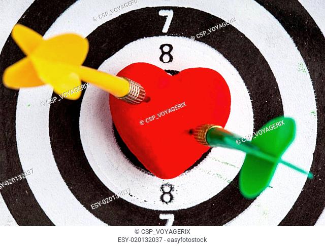 Black white target with two darts in heart love symbol as bullseye