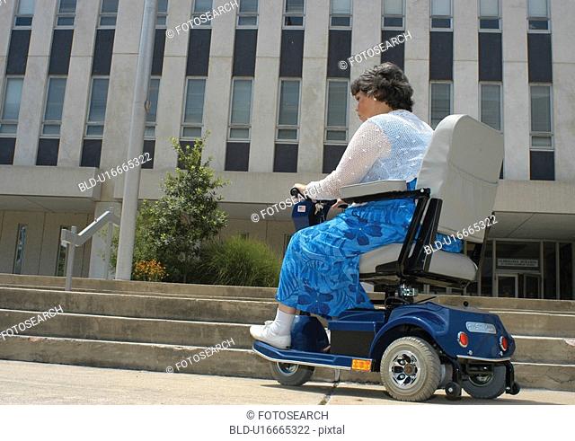 Woman with a physical disability utilizing a power scooter/cart for mobility encountering barriers in large city