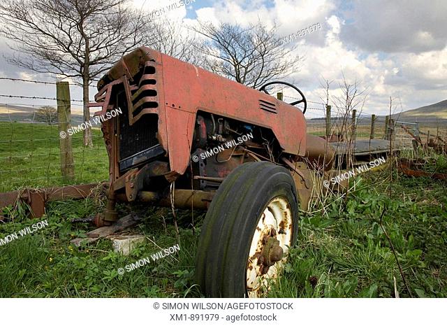 Disused old tractor in field