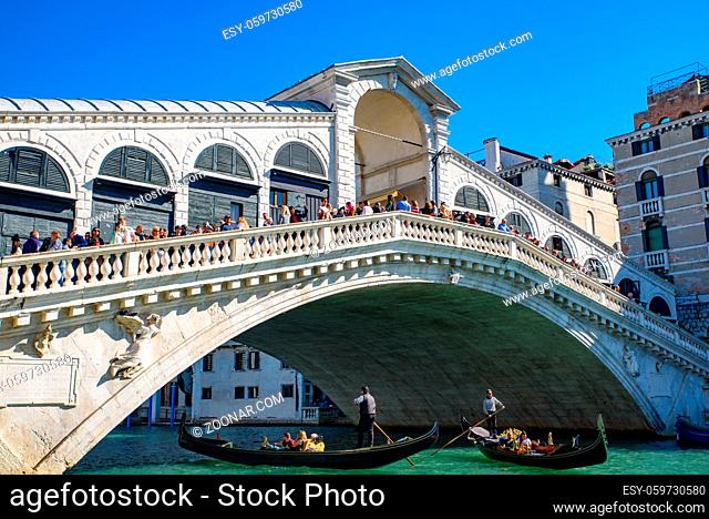 Gondola passing under Rialto Bridge (Ponte de Rialto) across Grand Canal, Venice, Italy