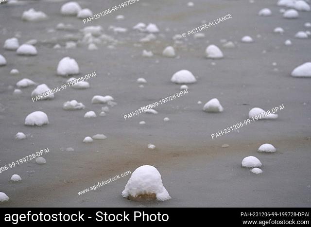 06 December 2023, Hamburg: Small mounds of snow lie on the frozen ponds in the snow-covered ""Planten un Blumen"" park. The cold and snow continue to have many...