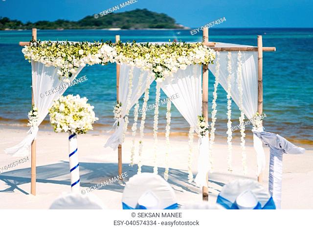 The wedding venue decoration on the beach, Arch decorated with flowers, floral, The panoramic ocean in the background. Blue and clear sky around 5pm before...