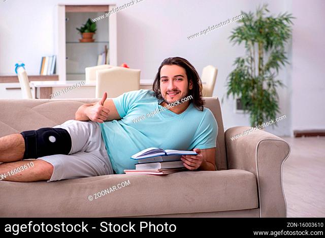 Young leg injured student studying at the home