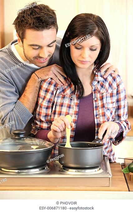 Young married couple cooking dinner