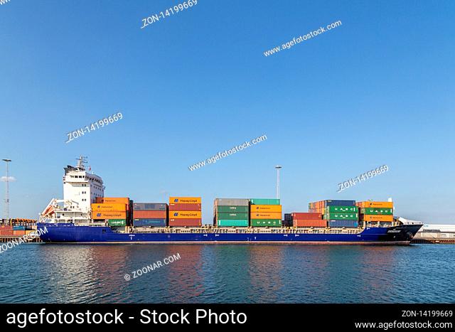 Copenhagen, Denmark - April 18, 2018: Side view of a container cargo ship anchored in the harbor