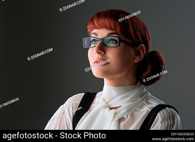 Closeup of beautiful young woman in white blouse and glasses over grey background