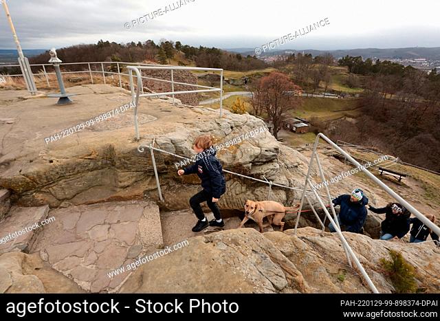 29 January 2022, Saxony-Anhalt, Blankenburg: Visitors enjoy the view over the Harz Mountains at Regenstein Castle. The sandstone rock on which the cave castle...