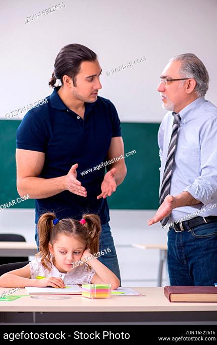 Young parent, old teacher and little girl in the classroom