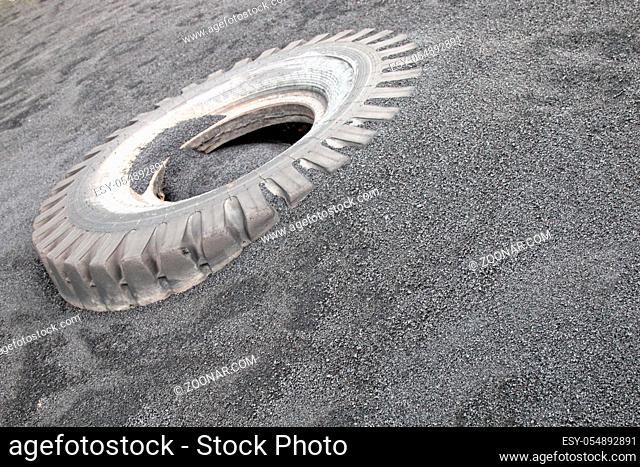 Truck tire cover among the black sand. Real tires will overcome even the Black desert, photo is intended for advertising high-quality wheels