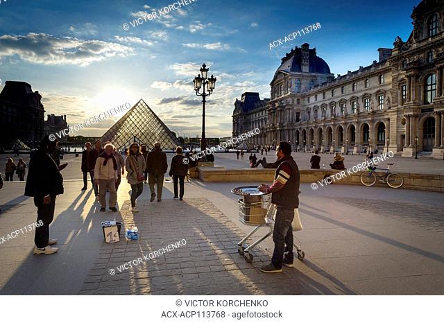 Chestnut seller at Louvre Pyramid at sunset
