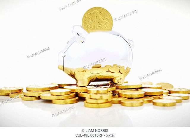 Stack of gold coins by piggy bank