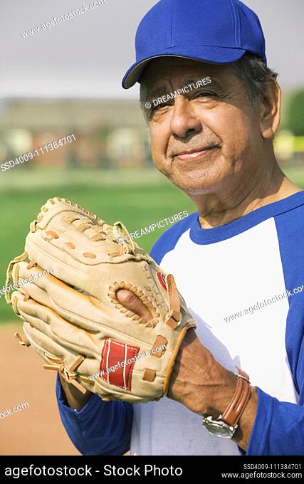 Senior Hispanic man playing on baseball team