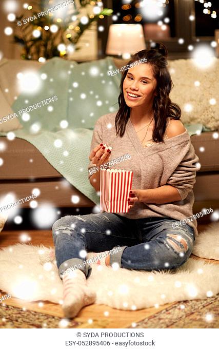 happy woman eating popcorn at home