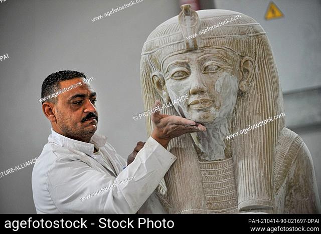 13 April 2021, Egypt, Obour City: A craftsman works on a model replica of an ancient Egyptian statue, at Konouz factory, the first factory in the region for...