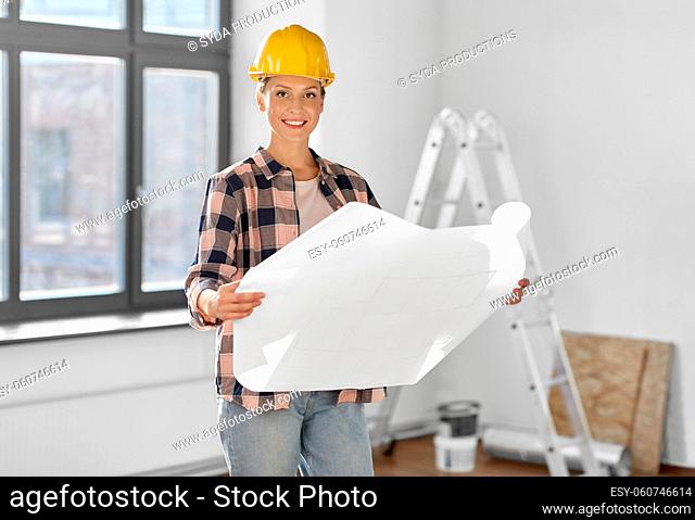 woman in helmet with blueprint at home