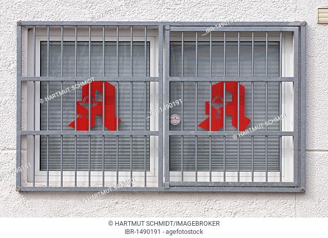 Barred window of a pharmacy, two logos on the windows, alarm monitoring, security, drugs