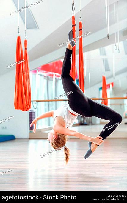 Fly yoga. Young woman practices aerial anti-gravity yoga with hammock